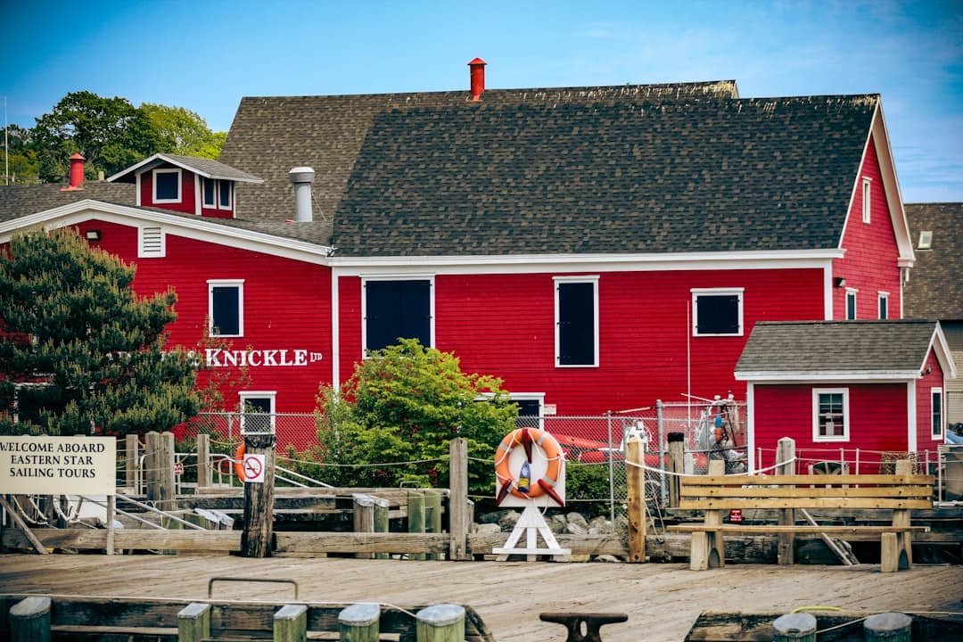 Red building with "knickle" sign by a harbor.
