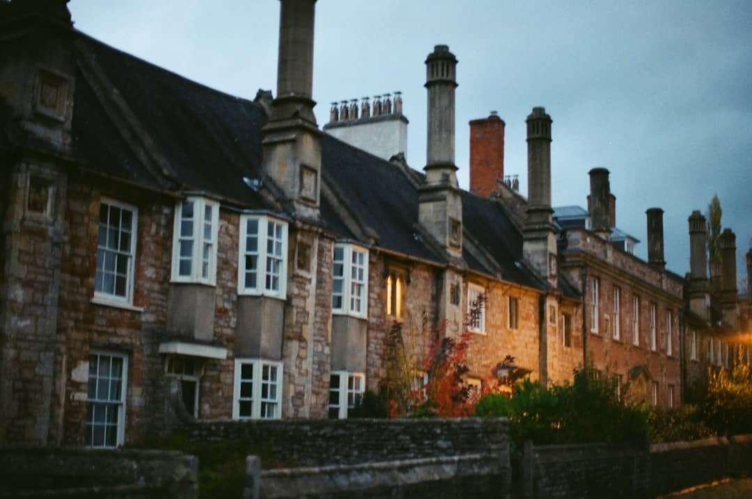 Row of historic stone buildings with tall chimneys