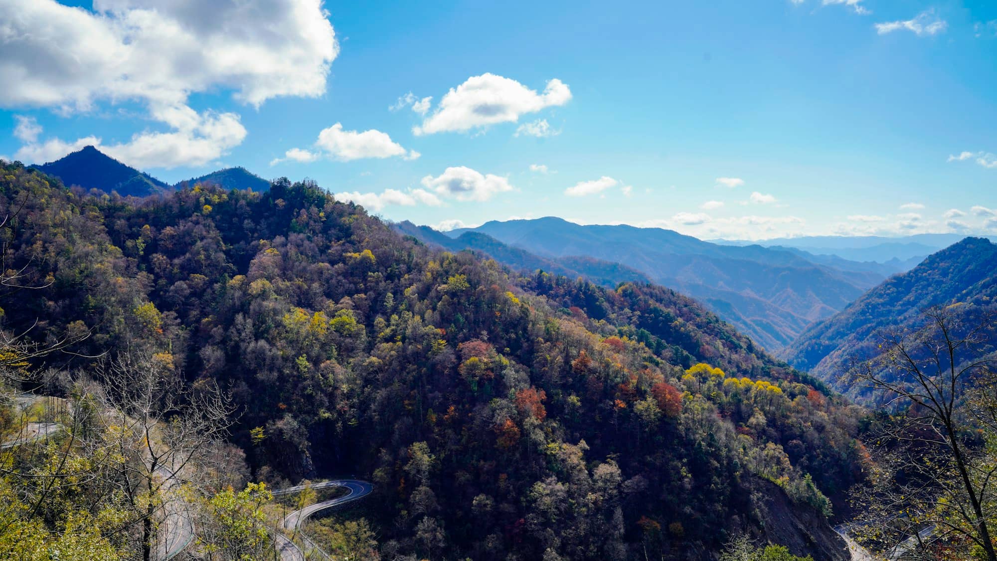 a scenic view of a winding road in the mountains