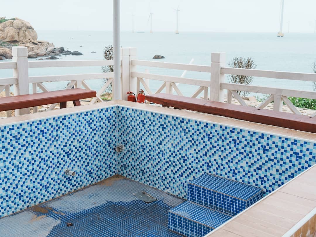 Small tiled pool overlooking the ocean with wind turbines.