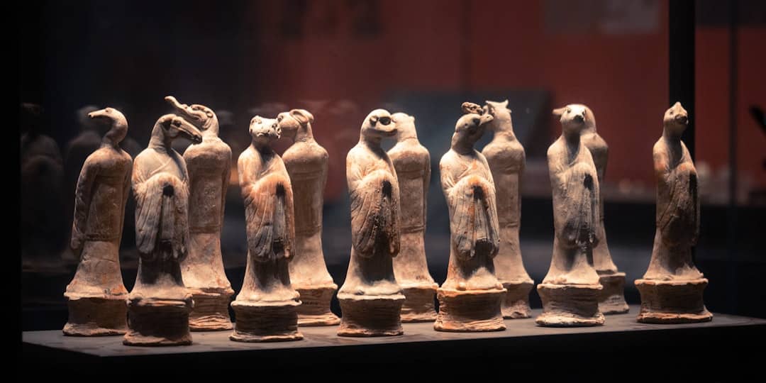 Ancient pottery statues are displayed in a museum.