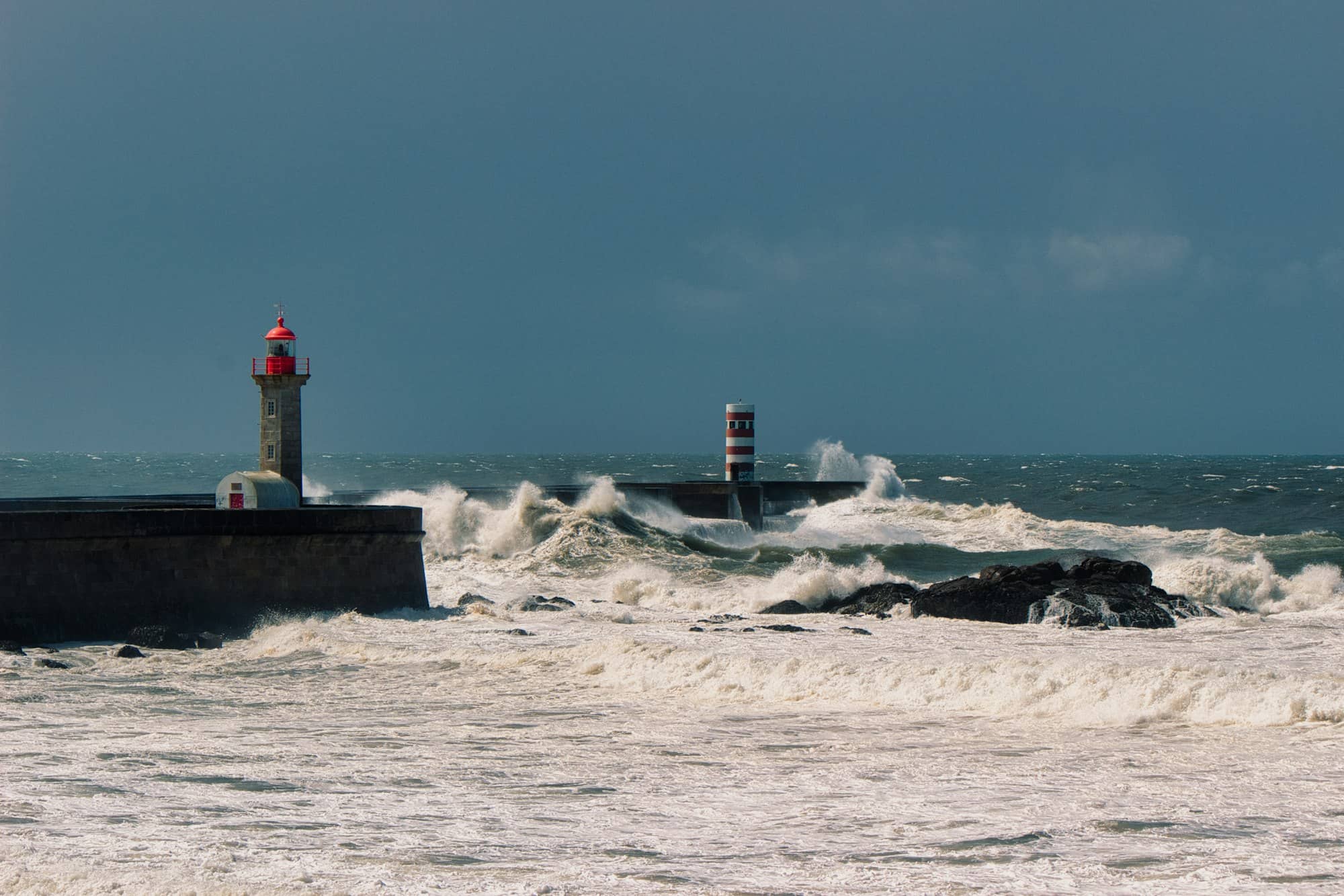 Rough seas crash near lighthouses.