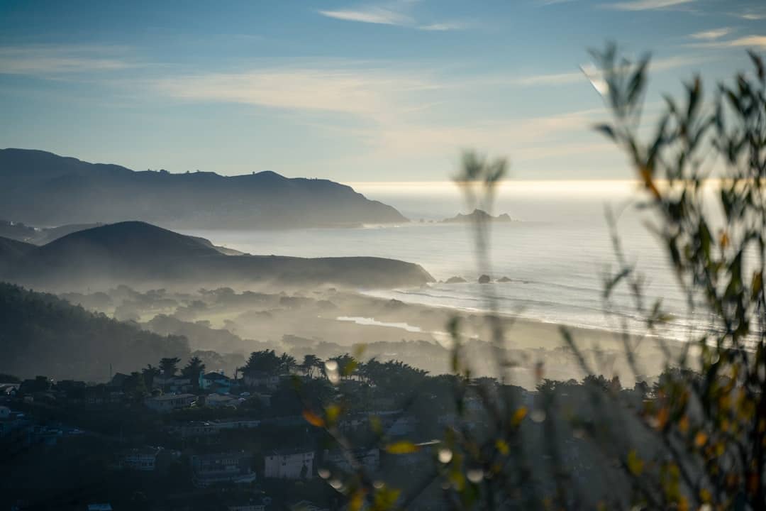 a view of a body of water with hills in the background