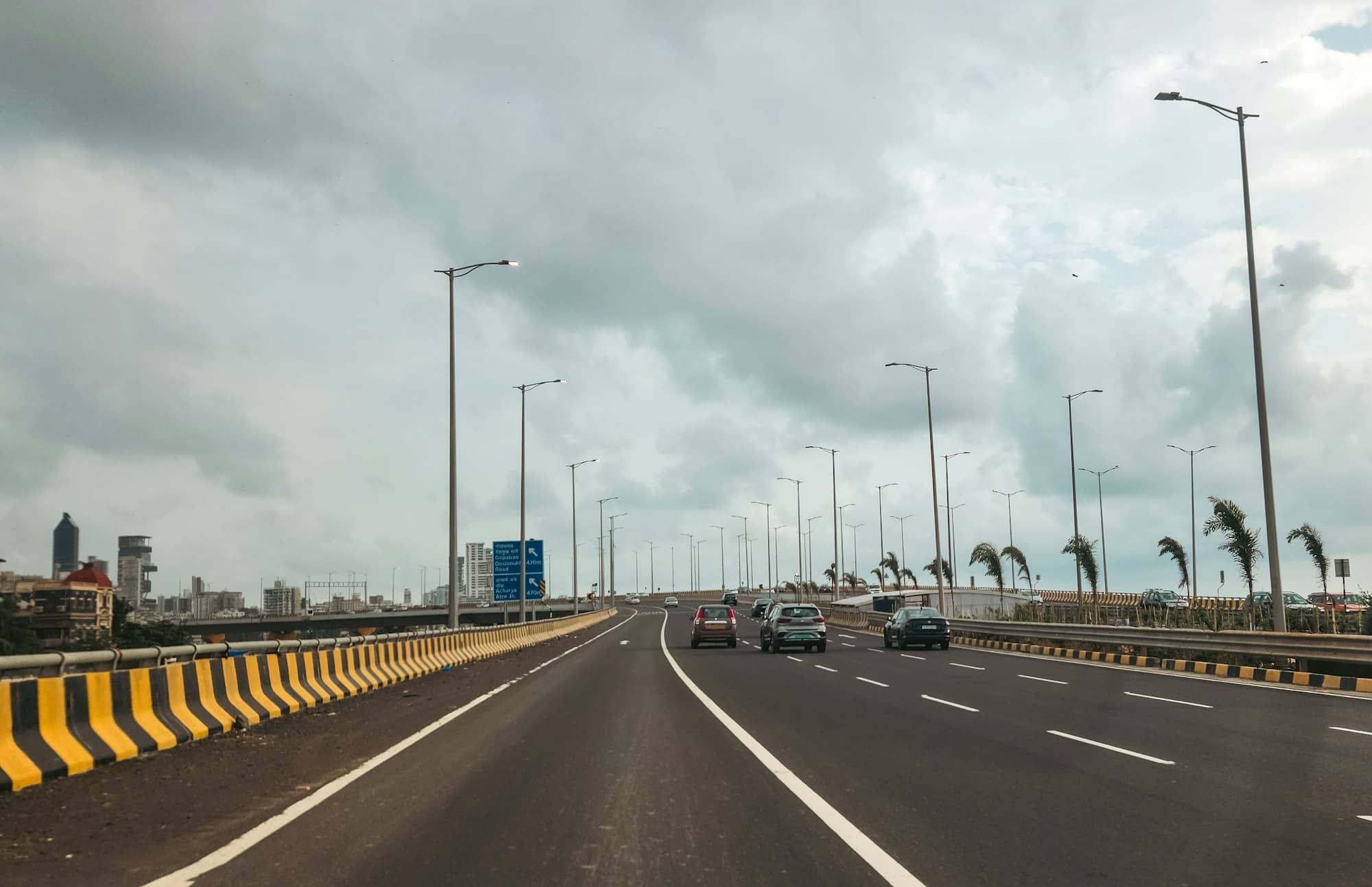Cars are driving on a long, empty highway.