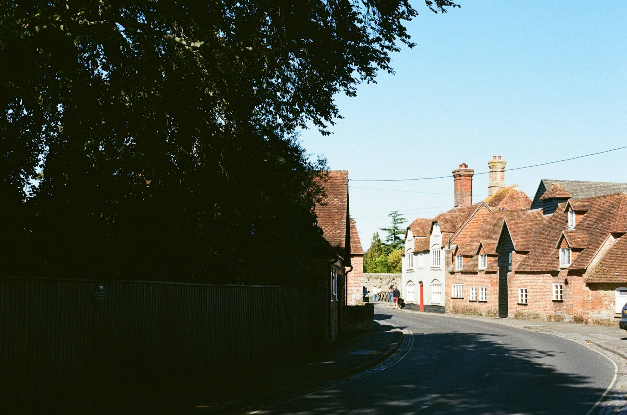 A quaint village street with traditional houses and trees.