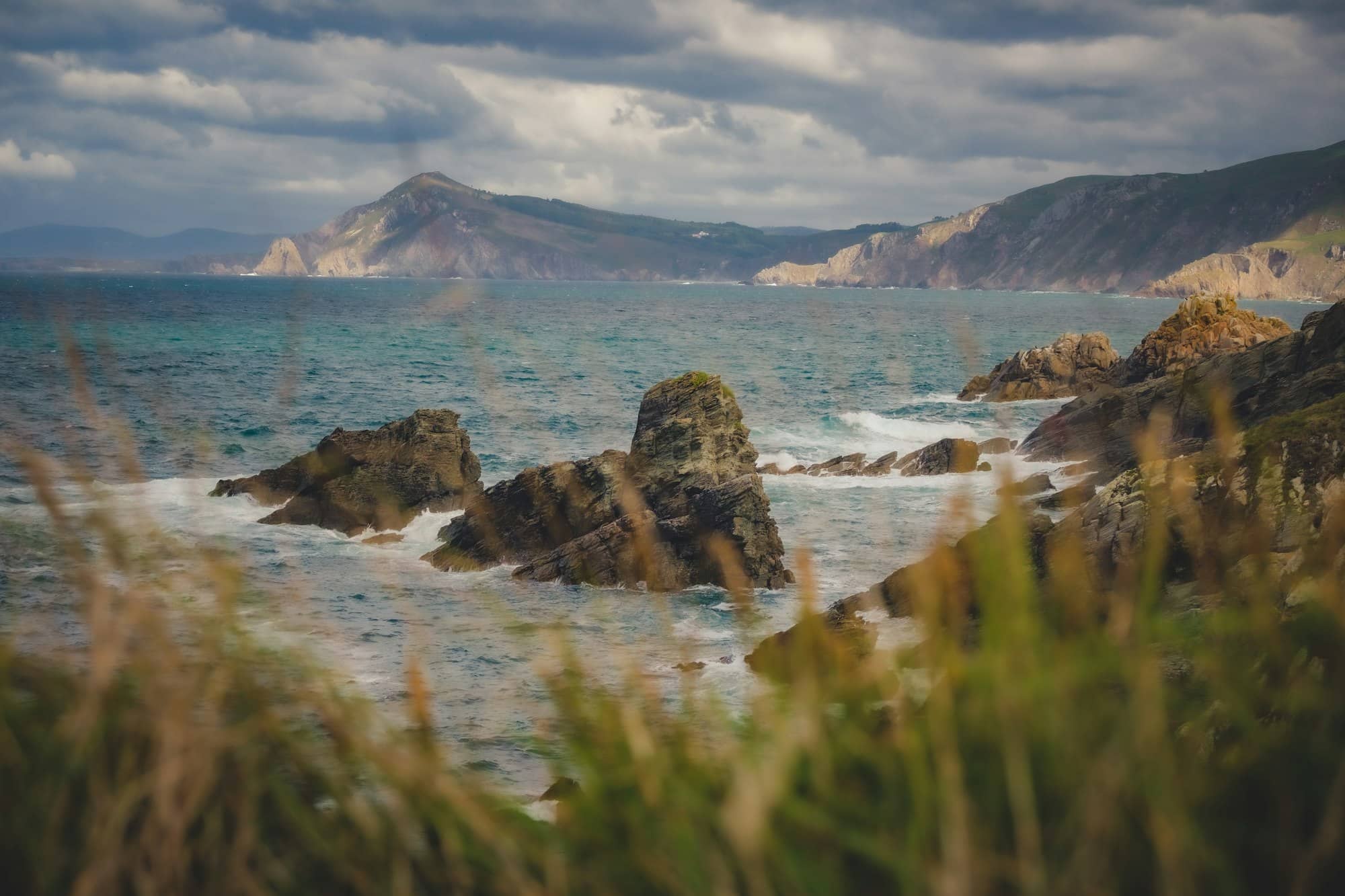 a body of water surrounded by rocks and grass