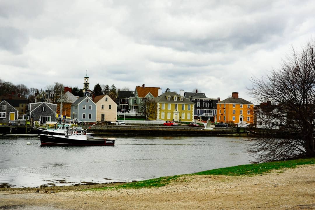 Colorful buildings line a waterfront with a boat.