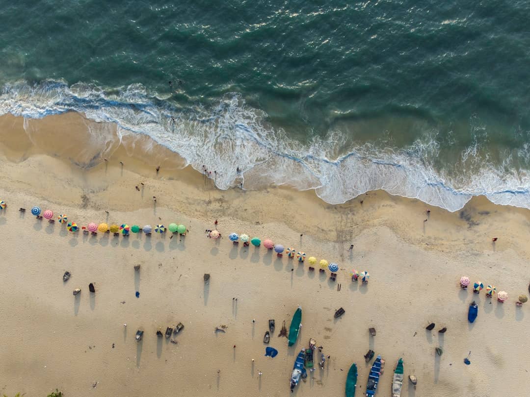 a group of people standing on top of a sandy beach