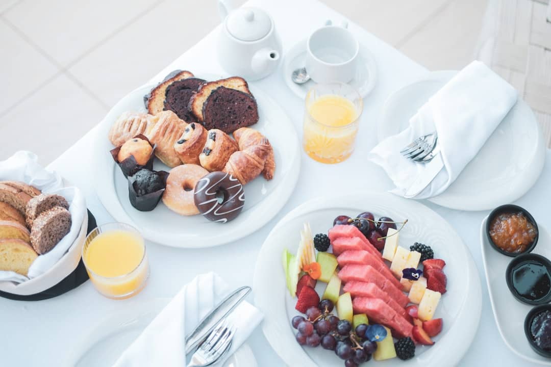 a white table topped with plates of food