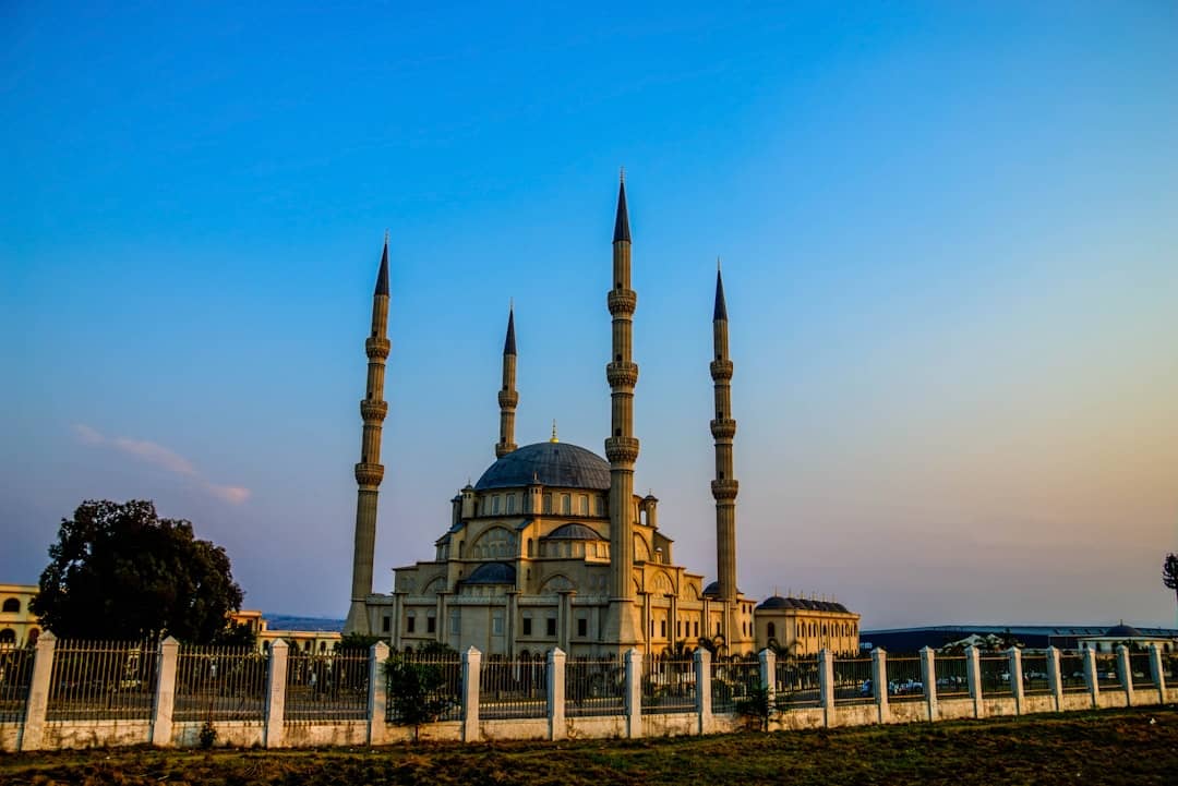 a large building with two towers and a fence in front of it
