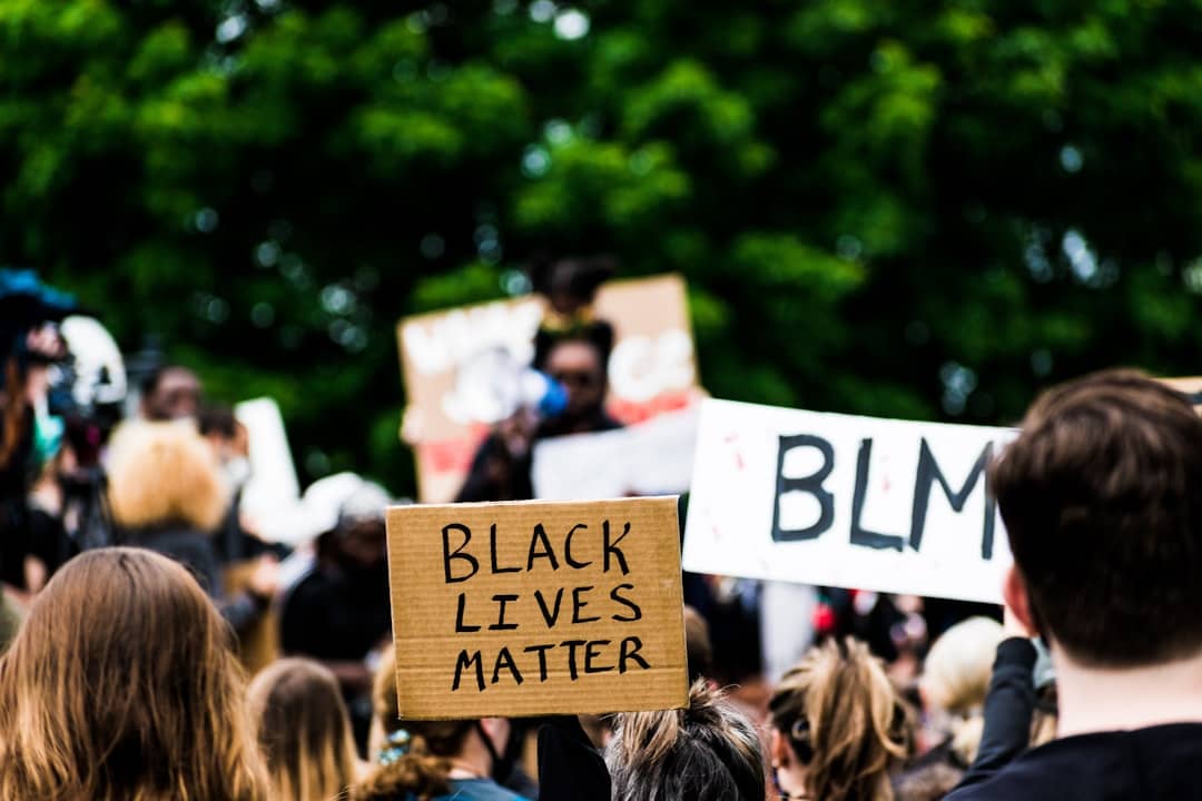 people holding white and blue wooden signage during daytime
