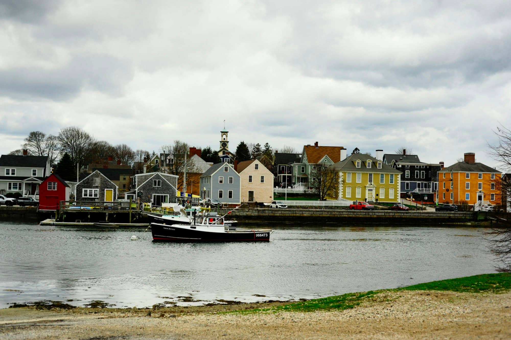 Colorful buildings line a harbor with a boat.
