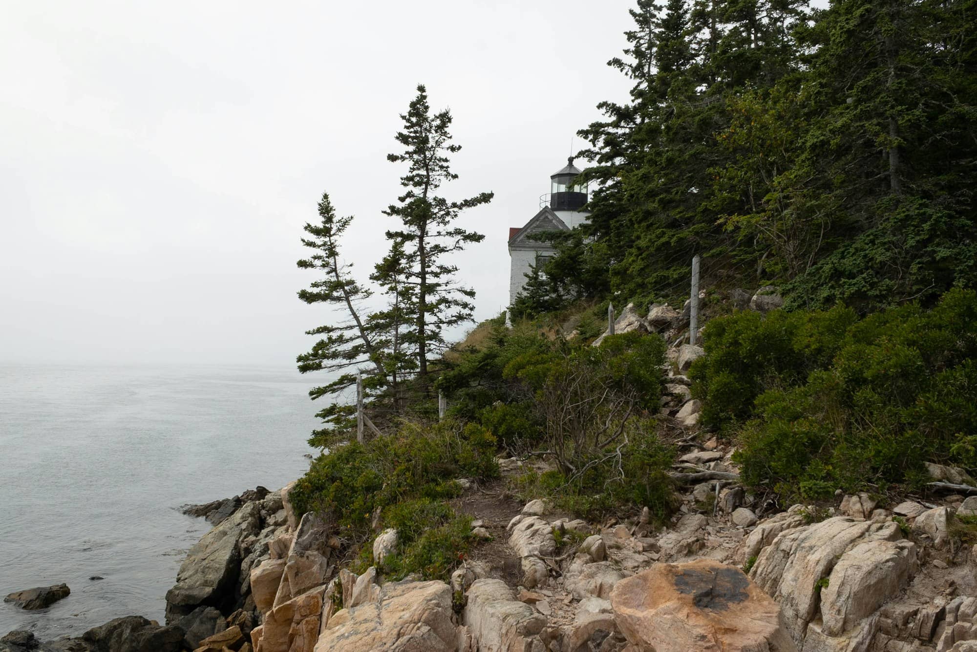 A lighthouse on top of a rocky cliff next to the ocean