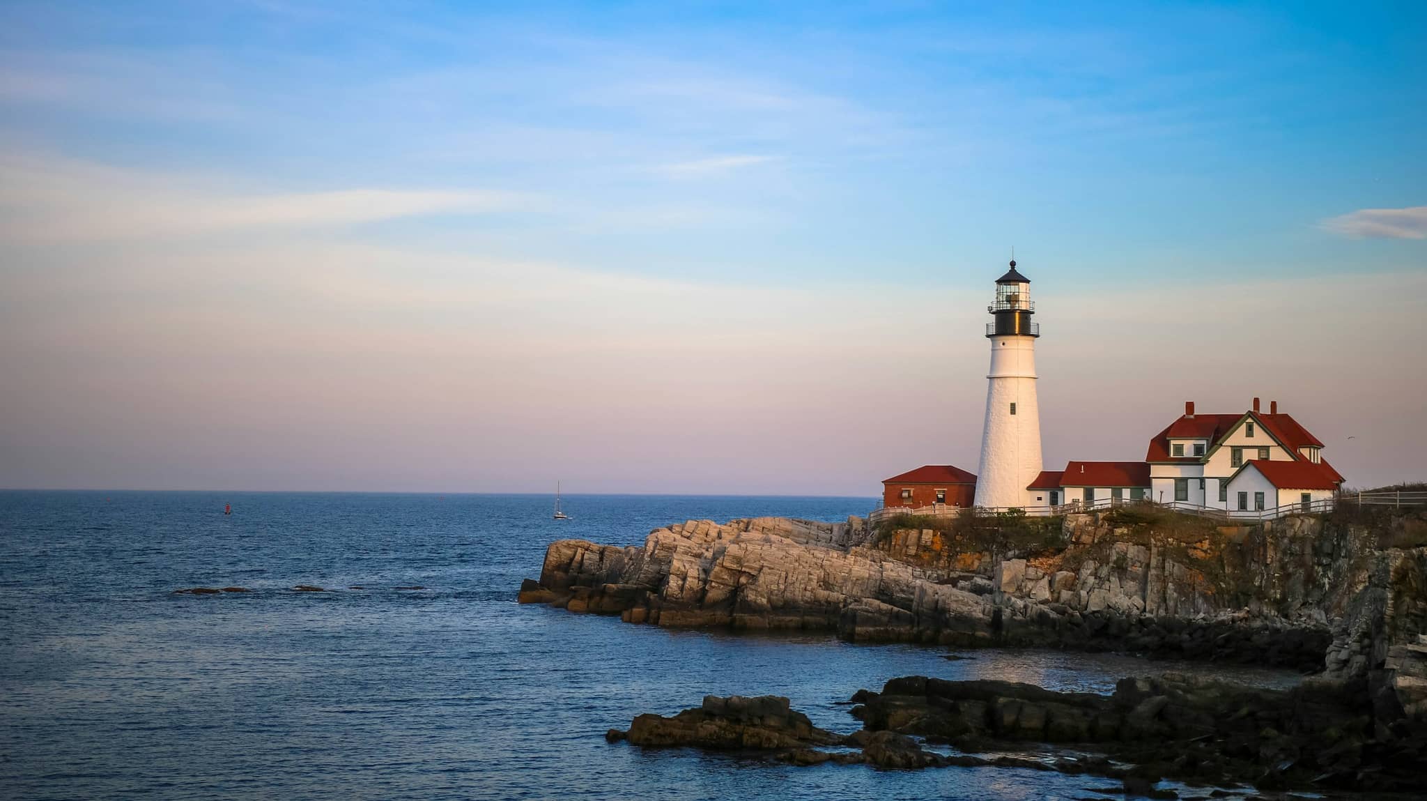A white lighthouse standing above the water