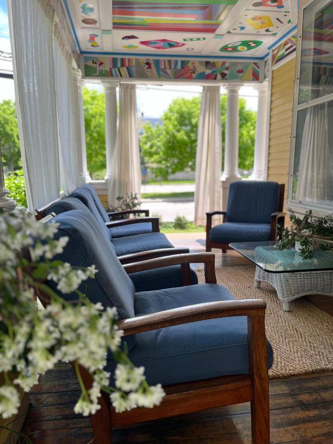 a living room with blue couches and chairs on a porch at Munroe Inn Boutique Hotel in Auburn