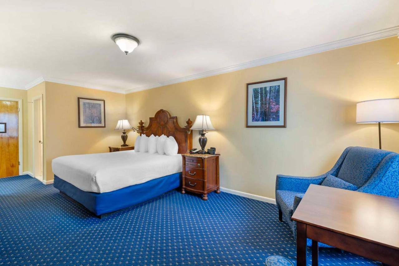 a hotel room with a bed and a desk and a chair at Best Western White House Inn in Bangor