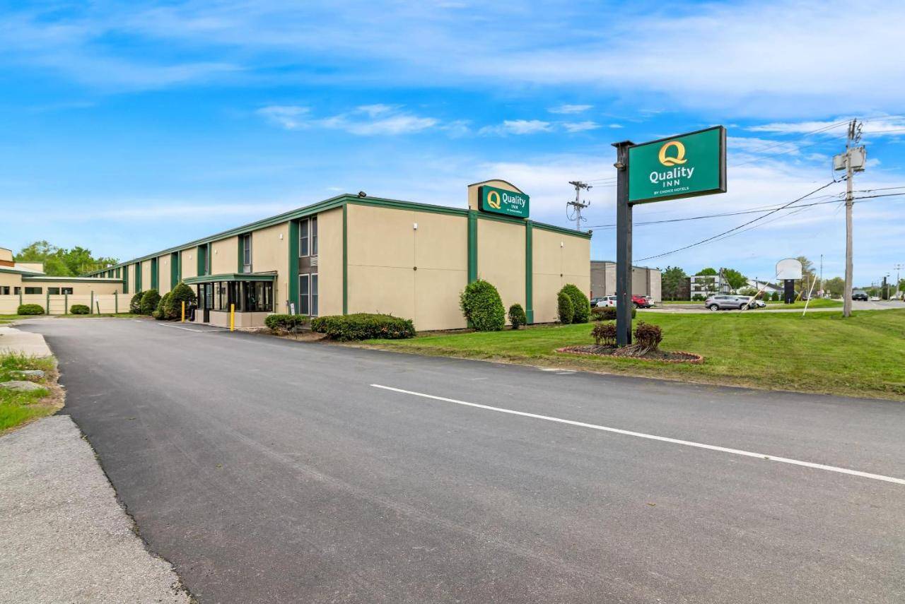 a building with a sign on the side of a road at Quality Inn Bangor Airport in Bangor