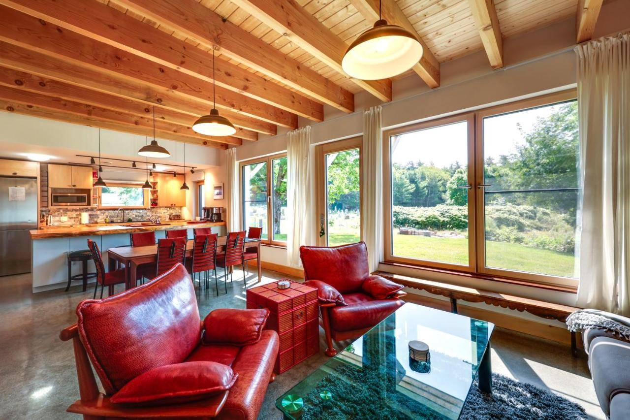 a living room with red chairs and a table at Acadia Home with Rooftop Deck - Close to Trails! in Otter Creek