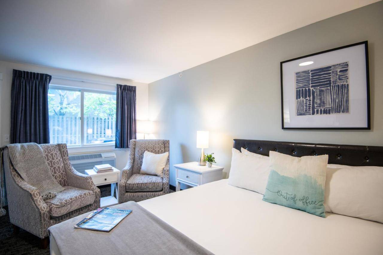 a hotel room with a bed and two chairs at Anchorage Motel in Bar Harbor