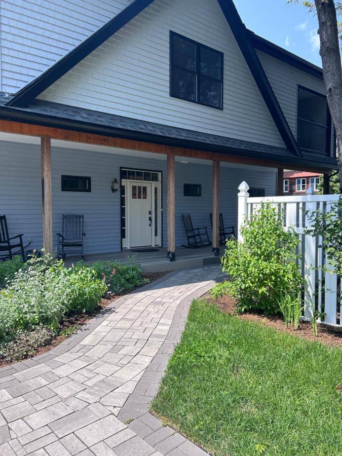 a house with a patio and a white fence at Canterbury Suites B&B in Bar Harbor