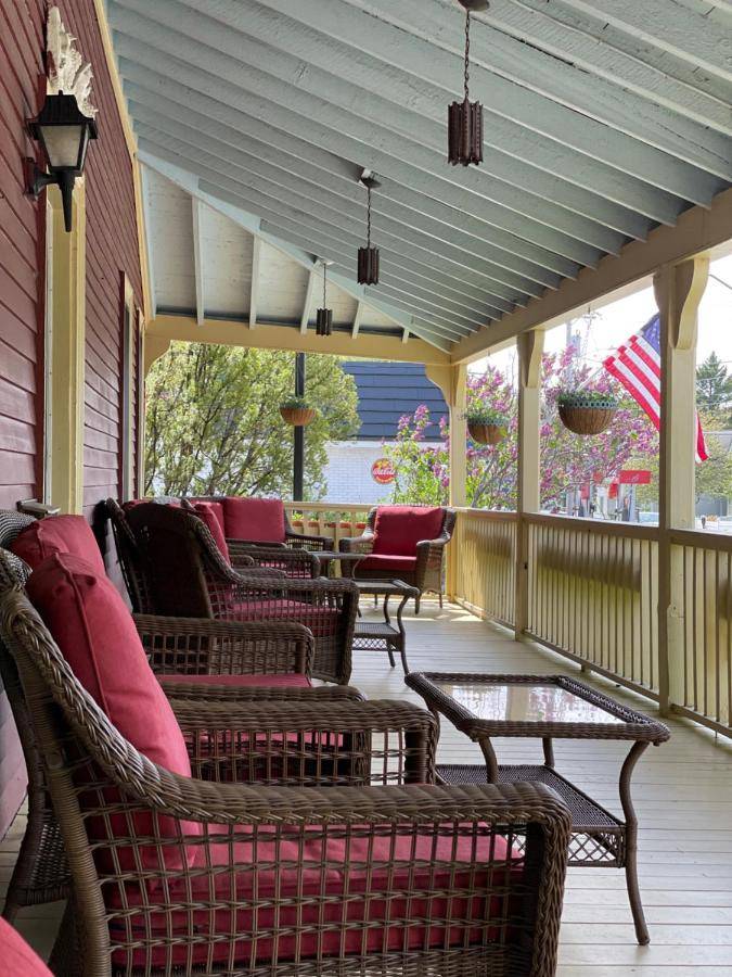 a screened in porch with chairs and a table at Central House Inn in Bar Harbor