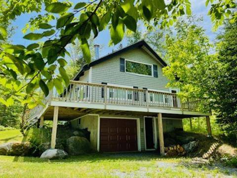 a house with a large deck on top of it at Chalet with a Private Beach in Acadia National Park in Bar Harbor