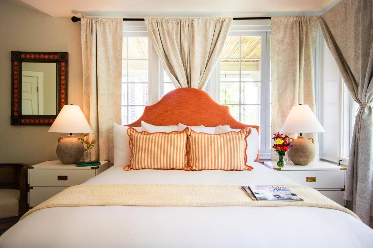 a bedroom with a large bed with two windows at Cleftstone Inn in Bar Harbor