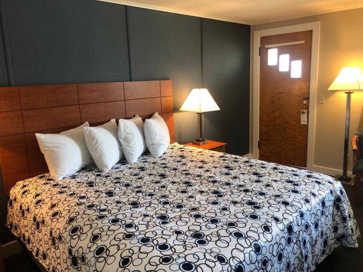 a hotel room with a bed with white pillows at Edenbrook Motel in Bar Harbor