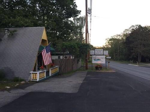 a house with an american flag on the side of a road at Hanscom's Motel & Cottages in Bar Harbor
