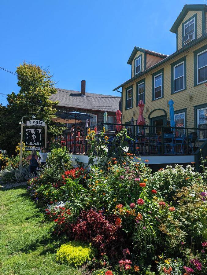 a garden in front of a house with flowers at Historic 2 Cats Inn in Bar Harbor