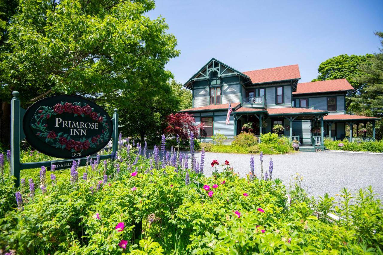 a sign in front of a house with flowers at The Primrose in Bar Harbor
