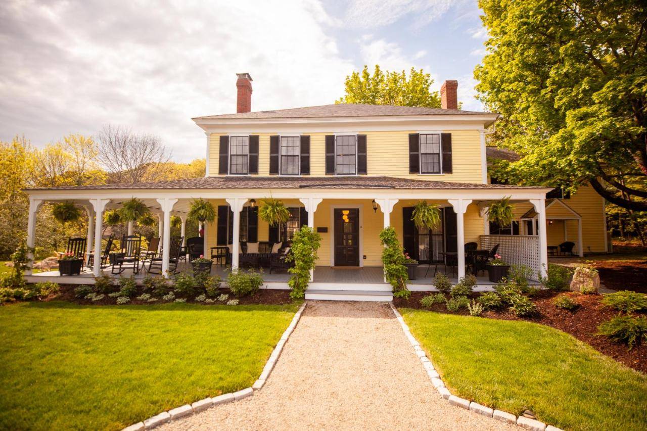 a white house with a porch and a lawn at Yellow House Inn in Bar Harbor