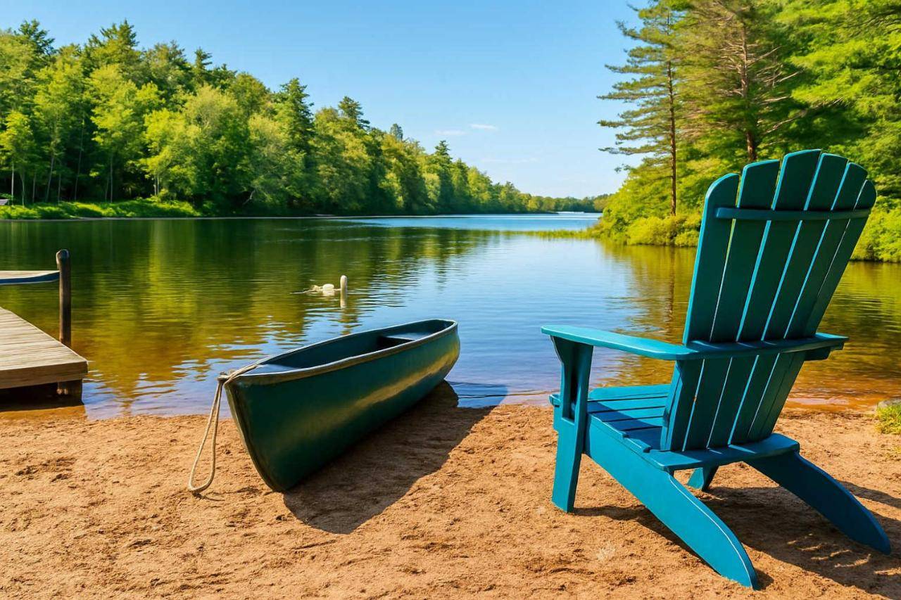 a chair and a boat on the shore of a lake at Sunset Chalet in Belgrade