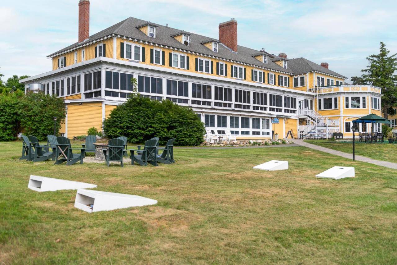 a large yellow and white building with chairs in a field at The Bethel Resort & Suites in Bethel