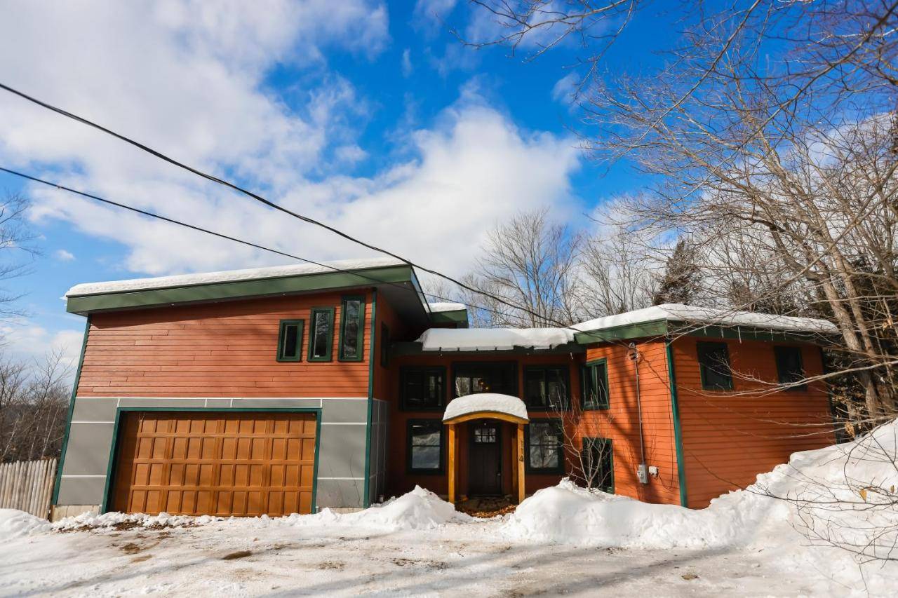 a house with a garage in the snow at Chasing the Slopes in Bethel