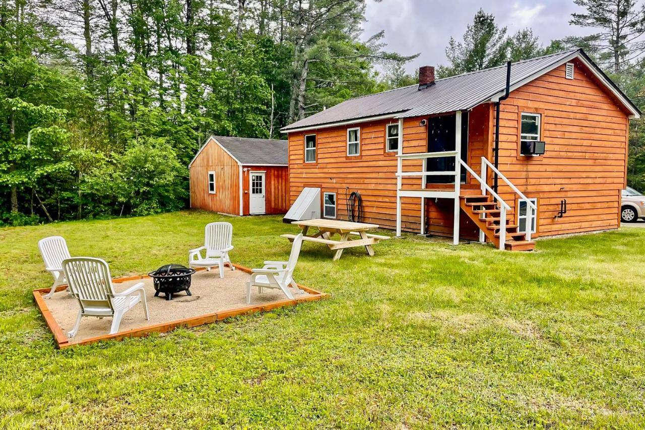 a cabin with a picnic table and chairs in the yard at EZ Sunday Morning in Bethel