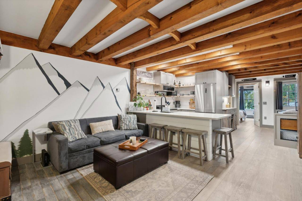 a living room with a couch and a kitchen at Riverbend Ski Retreat in Bethel