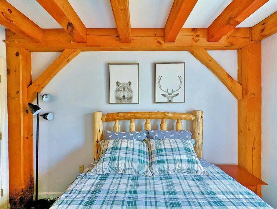 a bedroom with a bed with a checkered blanket at Newly Renovated & Furnished Condo, Only 3 min to Sunday River! in Bethel