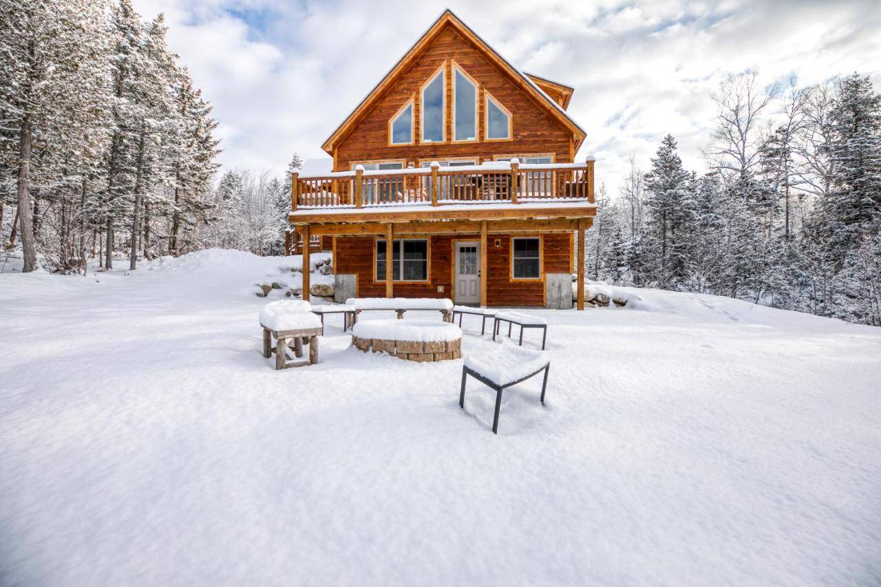 a log cabin in the snow with snow covered trees at The Escape at Thunder Snow in Bethel