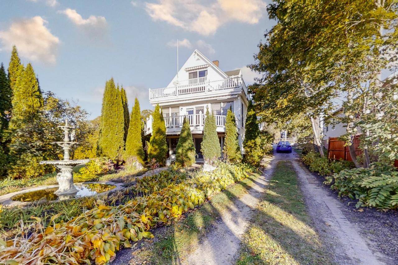 a white house with a garden and a fountain at Atlantic Gardens I in Boothbay Harbor