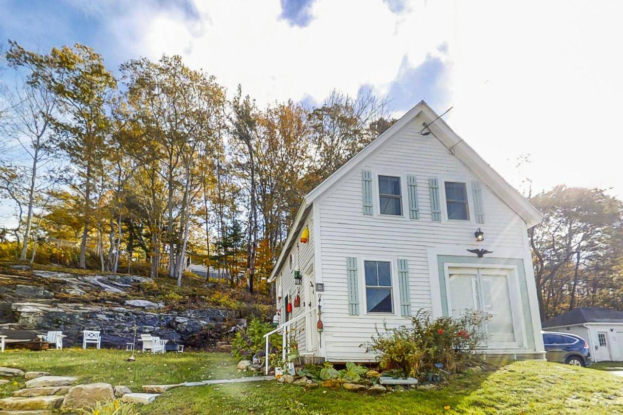 a white house sitting on top of a yard at Bayside Barn in Boothbay Harbor