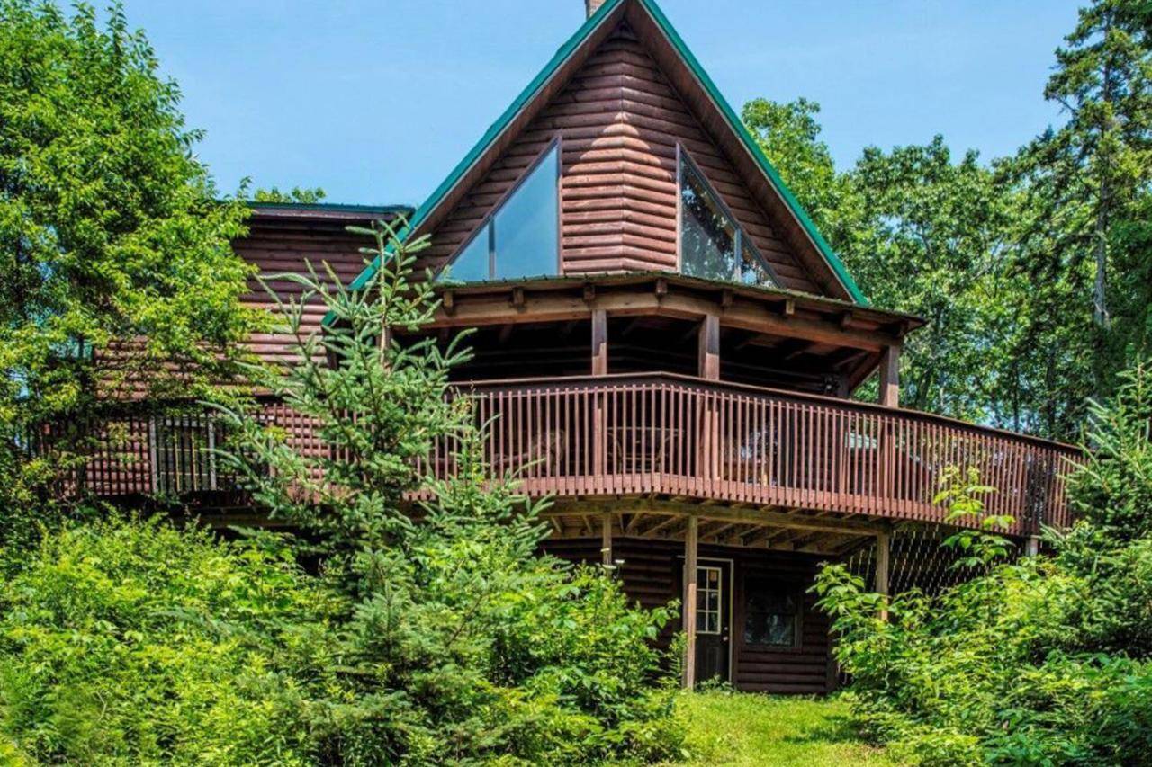 a large wooden house with a wrap around deck at Beaver Run Cabin in Boothbay Harbor