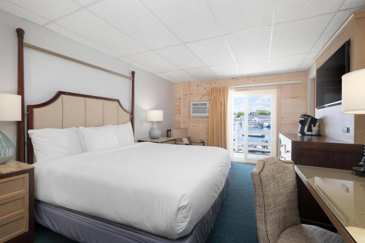 a bedroom with a large white bed and a window at Boothbay Harbor Inn in Boothbay Harbor
