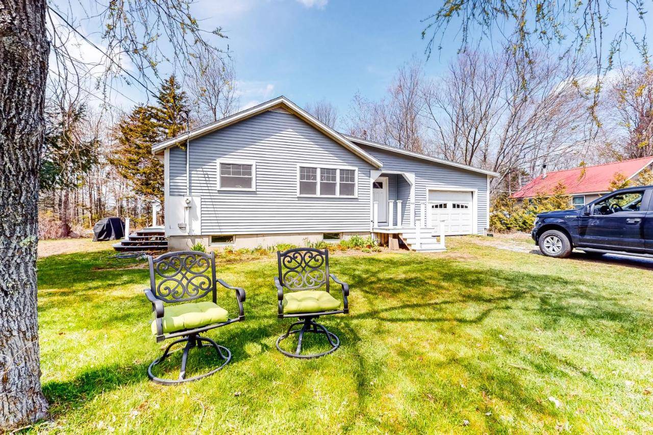 two chairs sitting in a yard in front of a house at Captains Cottage on Atlantic in Boothbay Harbor