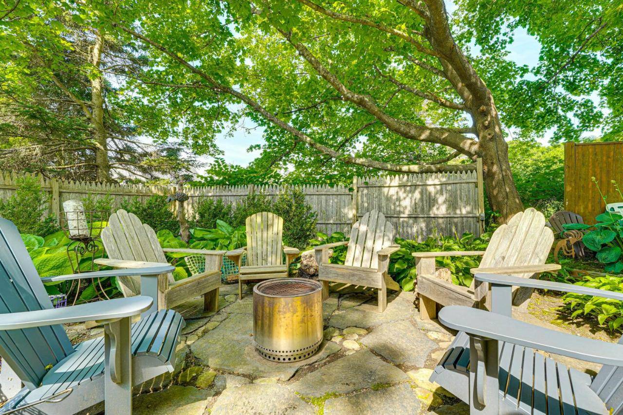 a yard with chairs and a tree and a fence at Charming Cottage with Patio, Walk to Boothbay Harbor in Boothbay Harbor