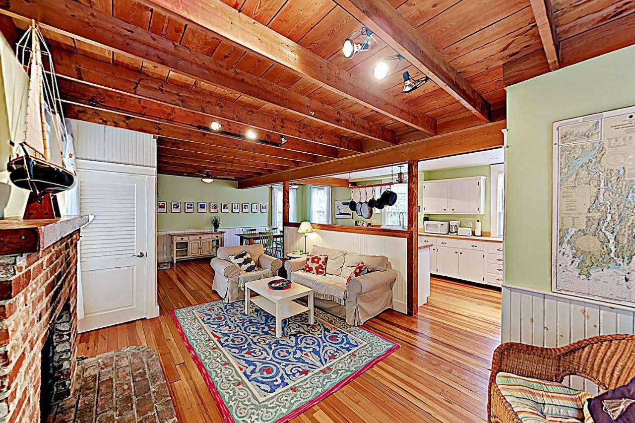 a living room with a couch and a table at Firehouse Cottage in Boothbay Harbor