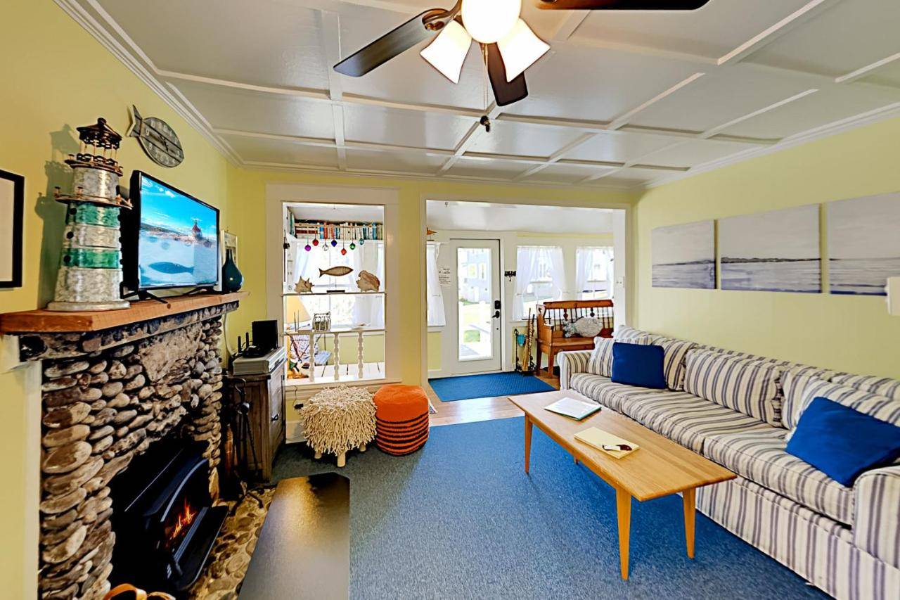 a living room with a couch and a fireplace at Fisher Hill Cottage in Boothbay Harbor