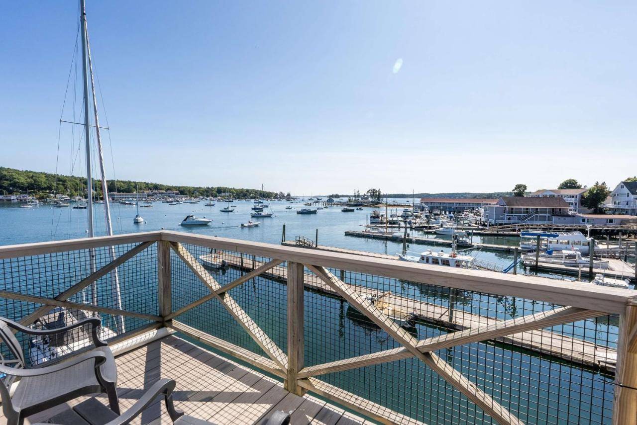 a balcony with a bench and a marina with boats at Fisherman's Wharf Inn in Boothbay Harbor