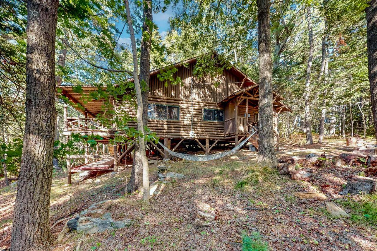 a log cabin with a hammock in the woods at Hammond Hideaway in Boothbay Harbor