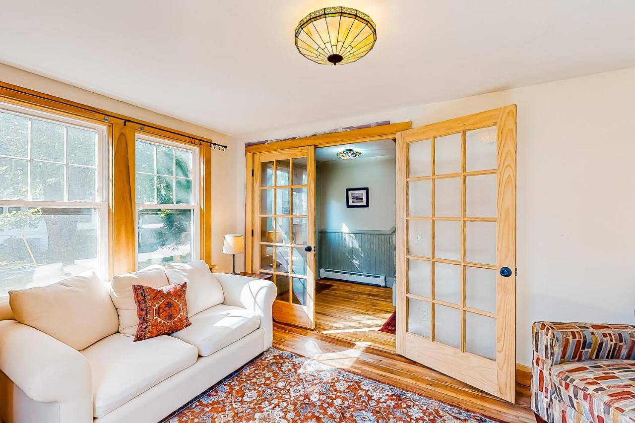 a living room with a white couch and a window at Harbor House in Boothbay Harbor